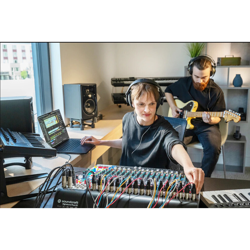 Soundcraft Signature Plus 22 en un estudio, con un portátil, un teclado controlador y un guitarrista grabando al fondo
