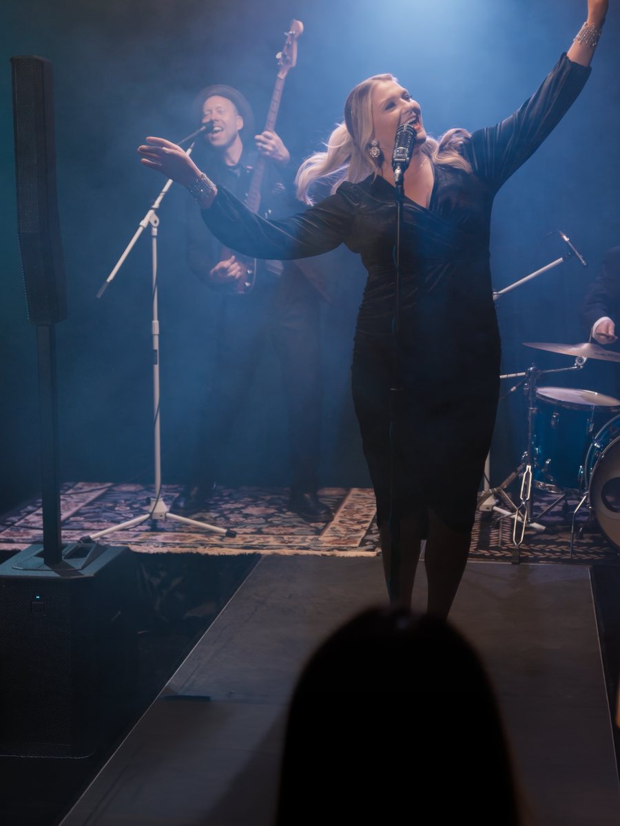 Cantante de jazz en un club con una columna Electro-Voice EVOLVE G2 en el escenario