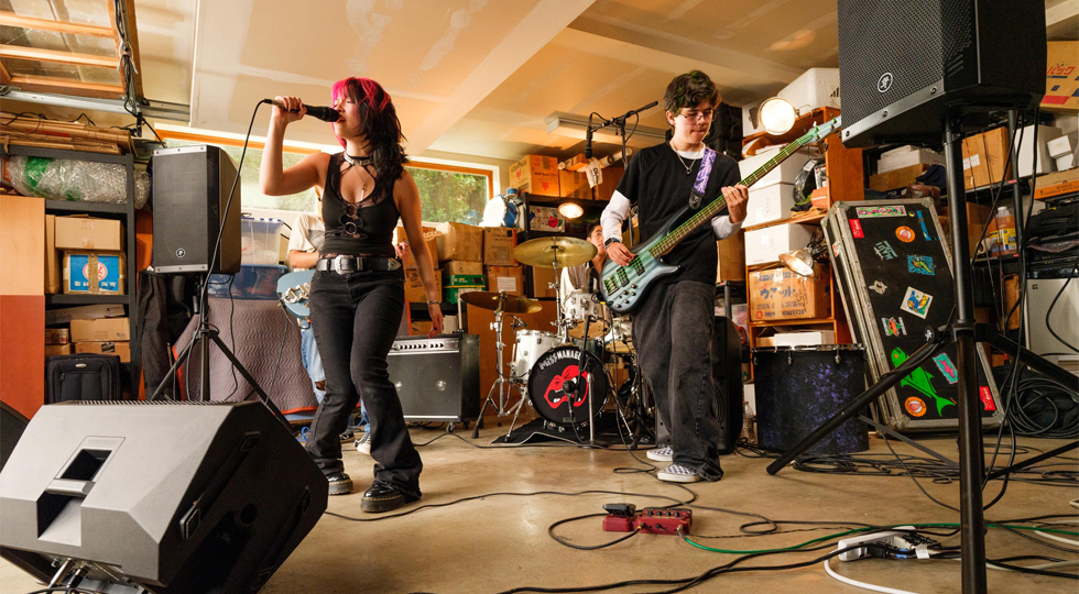 Grupo ensayando en un garaje con dos Mackie ThRash V2 en trípode y uno tumbado como monitor de suelo