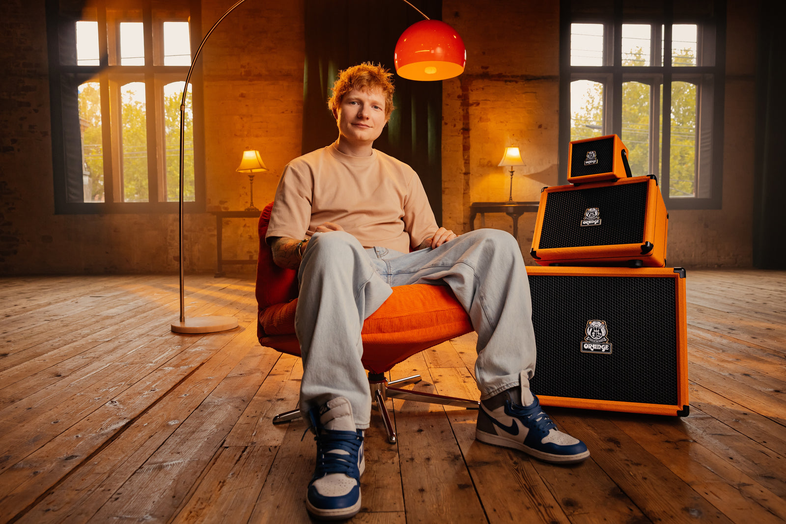 Ed Sheeran sentado junto a los tres amplificadores de la serie Orange Outlowd ES apilados: ES3, ES60 y ES100