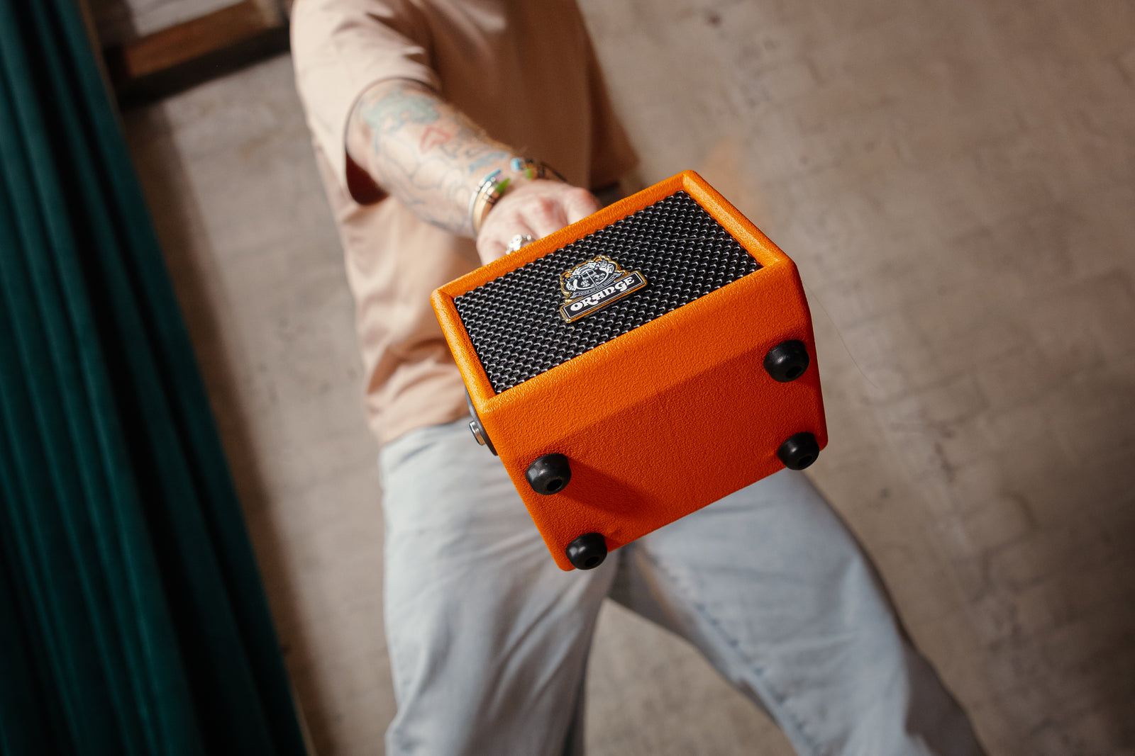 El Orange Outlowd ES3 sujeto con una mano, mostrando su tamaño de cubo portátil
