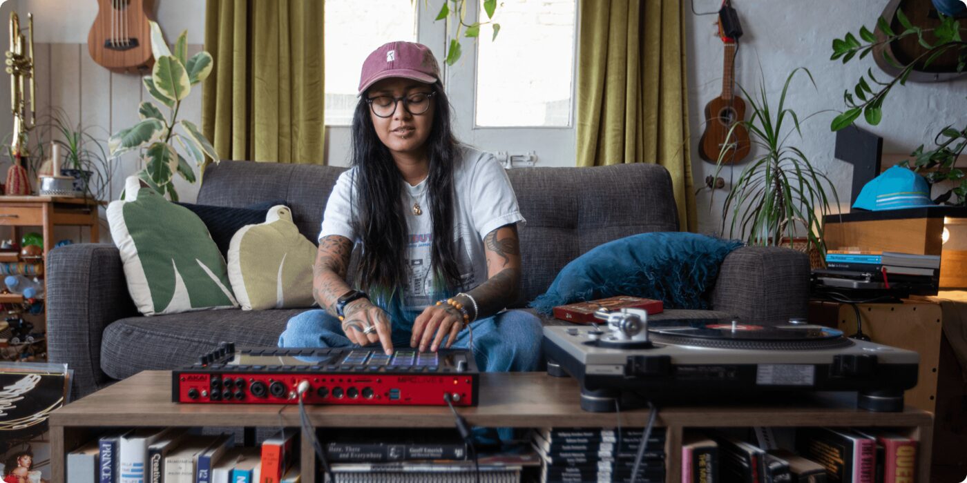 Productora trabajando con la MPC Live III en el salón de casa junto a un tocadiscos