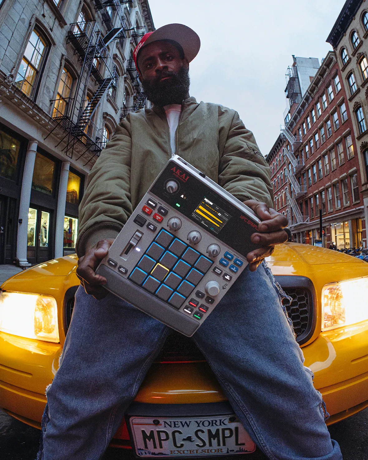 Productor sentado sobre un taxi de Nueva York sosteniendo la Akai MPC Sample