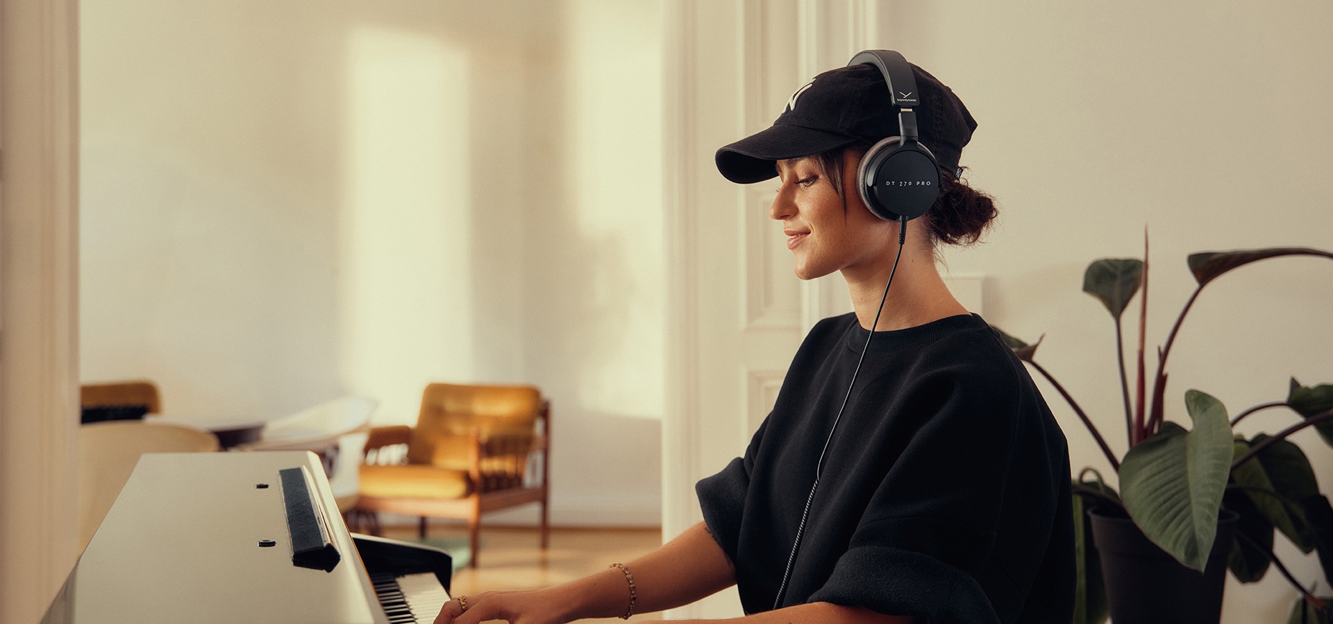 Mulher a tocar piano com os Beyerdynamic DT 270 PRO colocados