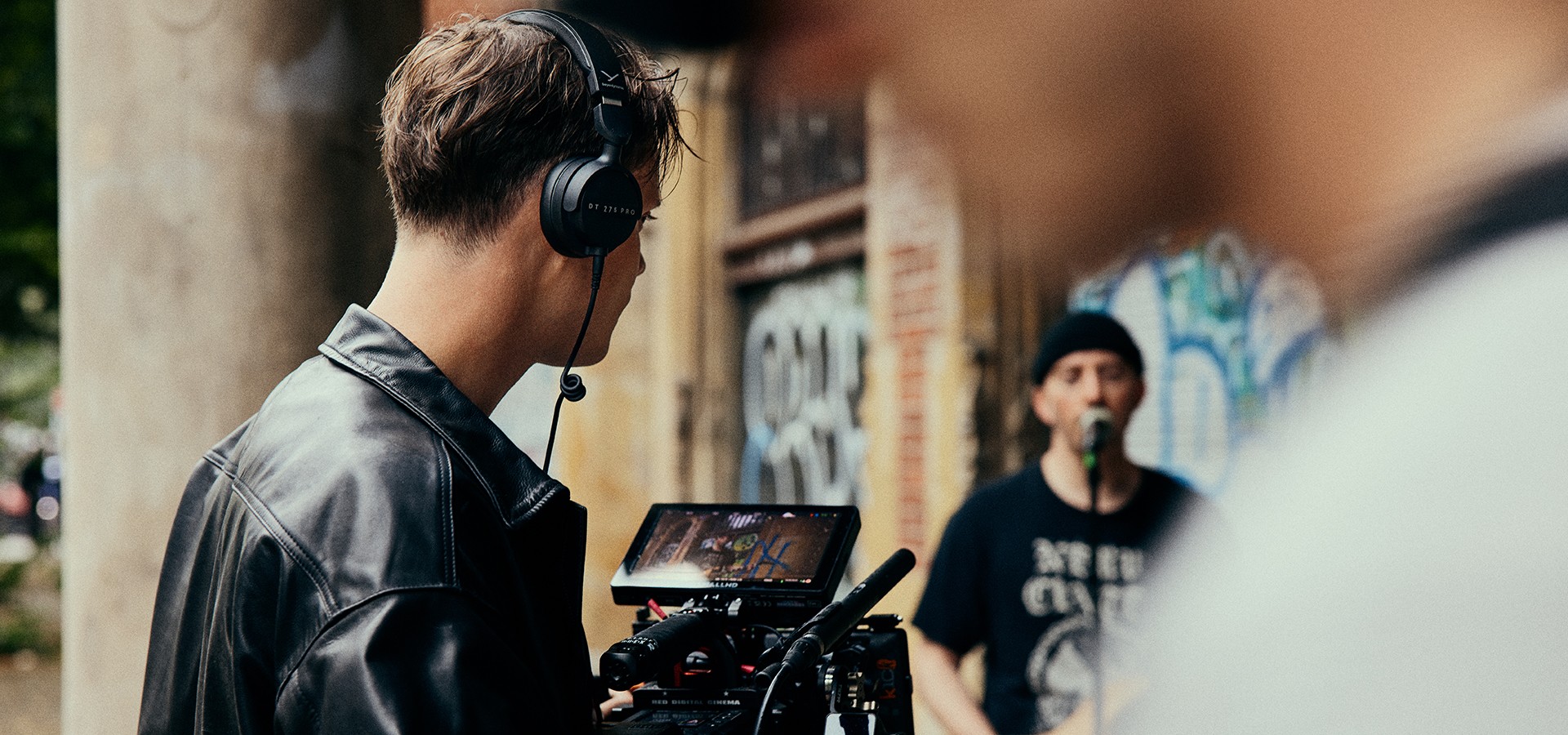 Operador de câmara numa filmagem na rua, a monitorizar o áudio com os Beyerdynamic DT 275 PRO