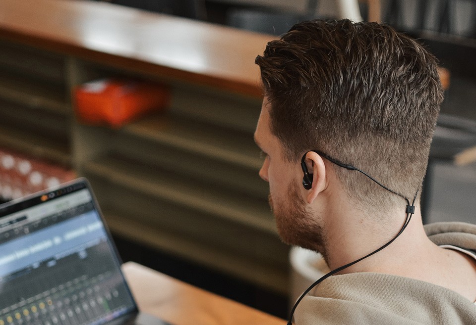 Técnico de som a trabalhar com um portátil e os Beyerdynamic DT 70 IE colocados