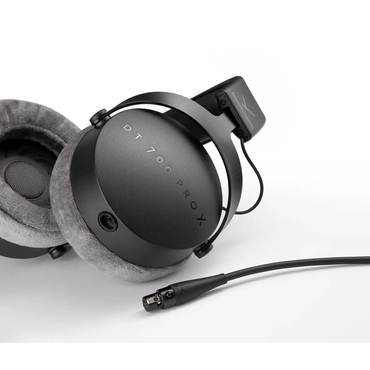 Pormenor da concha dos Beyerdynamic DT 700 PRO X com a serigrafia do modelo e o cabo mini-XLR desligado