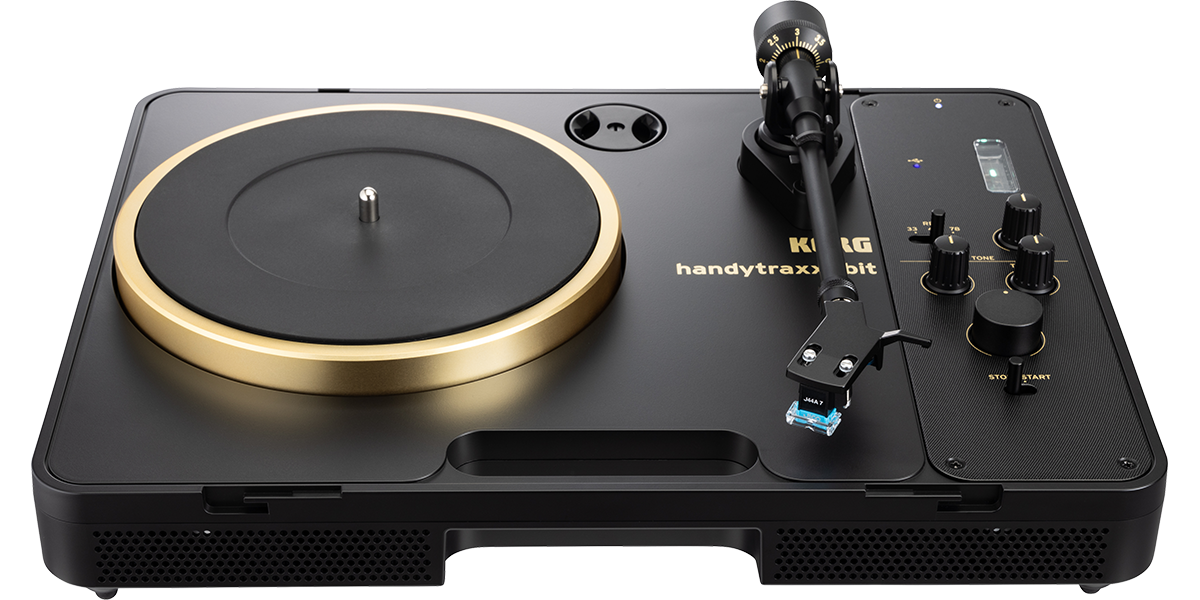 Korg handytraxx 1bit preto com o aro do prato dourado, em vista três quartos